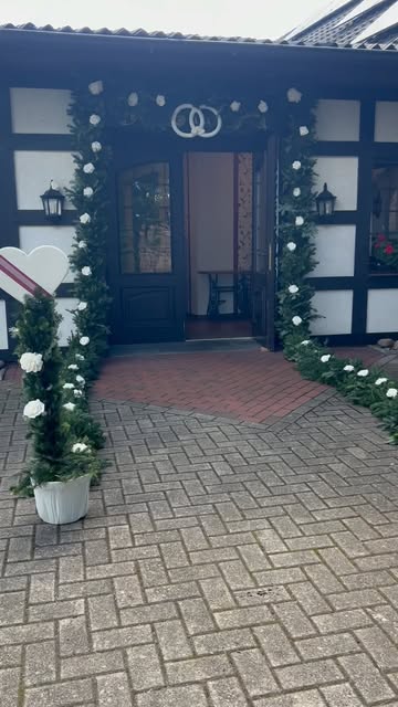 Hochzeitseinzug durch ein Spalier mit weißen Rosen