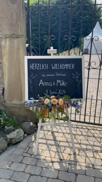 Kreidetafel mit der Aufschrift „Herzlich Willkommen Anna & Mike“